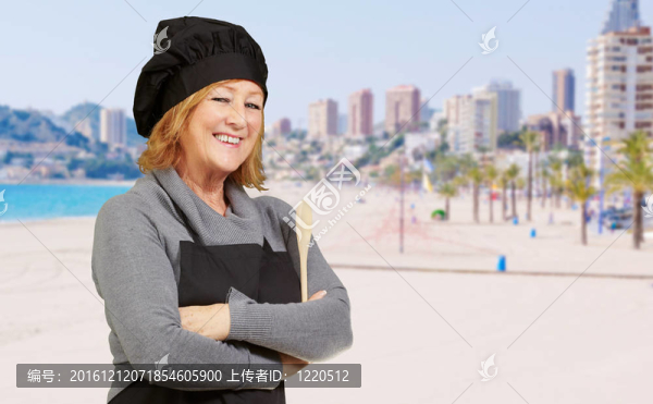 在海灘附近微笑的廚師中年女人肖像