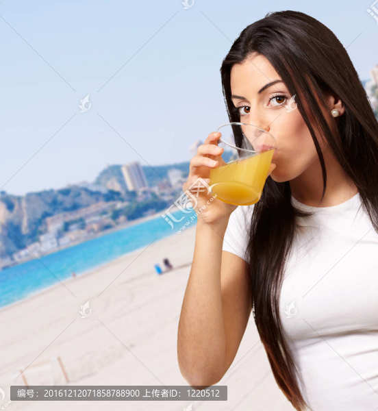 少女在海灘上喝橙汁的肖像