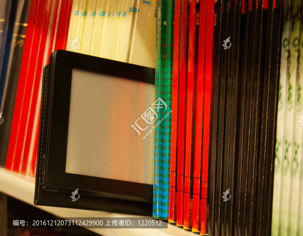 排在書架上的彩色書籍和電子書閱讀器