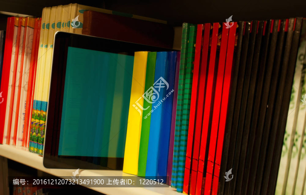 排在書(shū)架上的彩色書(shū)籍和電子書(shū)閱讀器
