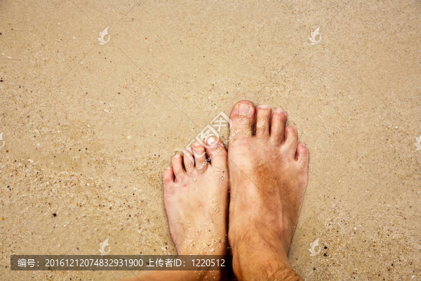 一個人的腳在細砂包圍的海水