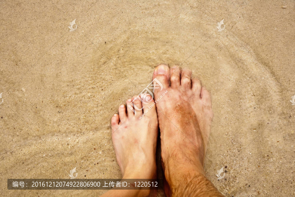 一個(gè)人的腳在細(xì)砂包圍的海水