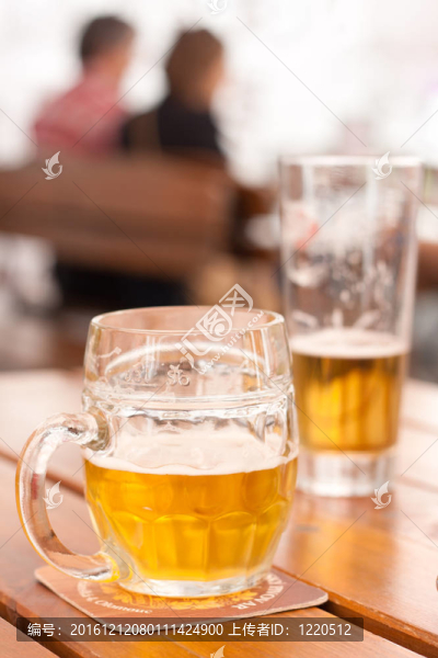 啤酒飲用：一個半填充啤酒杯在城市餐廳戶外活動桌上特寫