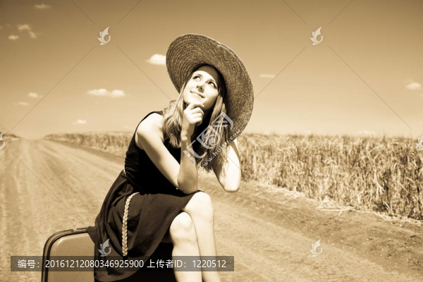 鄉(xiāng)村路上帶著手提箱的寂寞女孩。