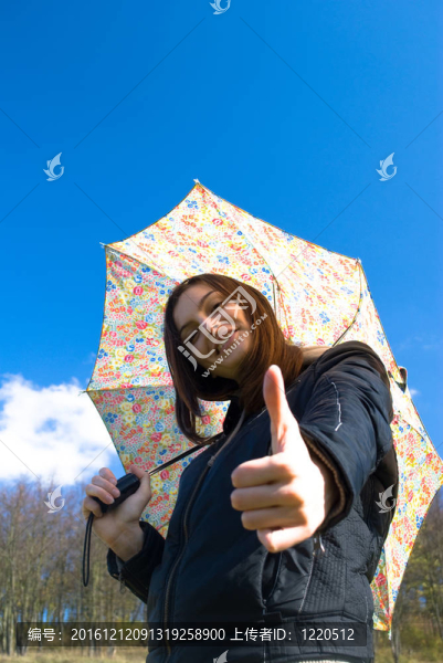 畫面中一位年輕快樂微笑的女孩站在雨中帶著傘