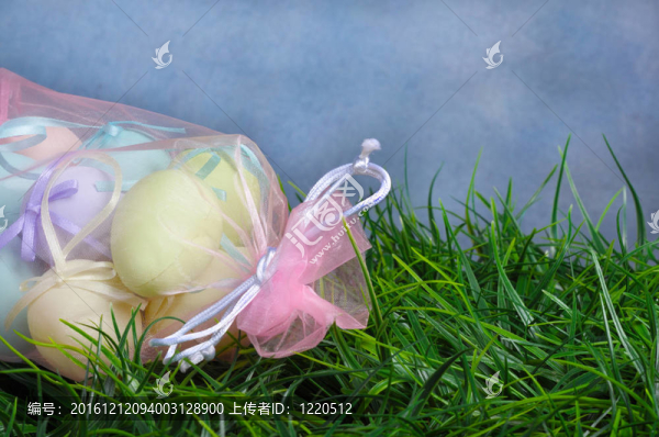 復(fù)活節(jié)彩蛋在粉紅色的袋子；青草與復(fù)制空間和藍色背景