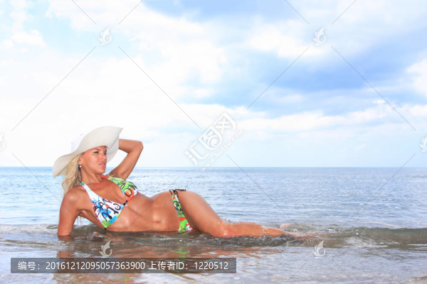 年輕美女?dāng)[在沙灘上