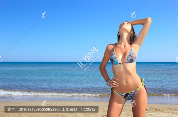 年輕美女?dāng)[在沙灘上