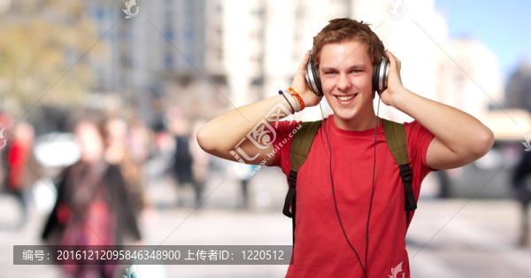 歡快的年輕學(xué)生在擁擠的街道上用耳機(jī)聽音樂的肖像