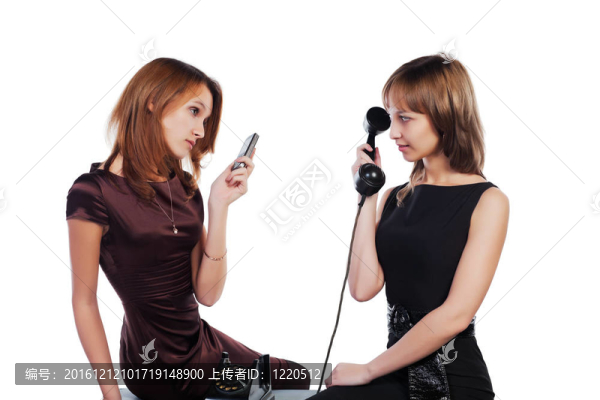 兩個年輕的女人與復(fù)古和現(xiàn)代電話