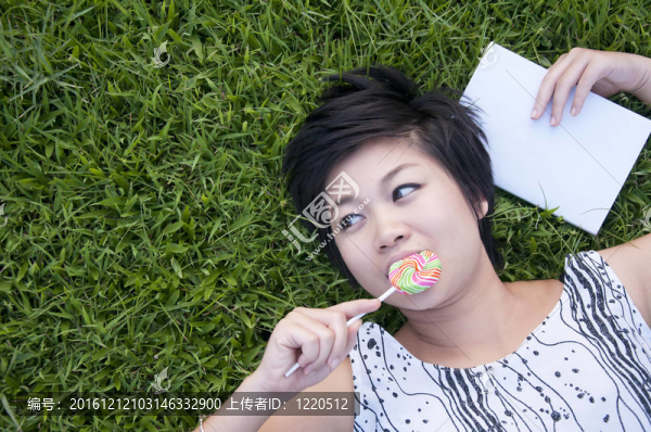 在公園里吃糖果的年輕女人