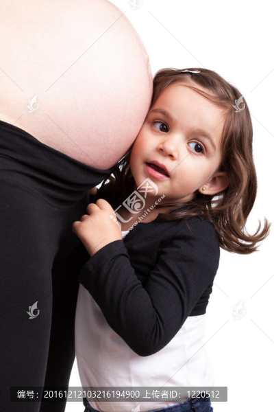 幸福的女兒抱著她懷孕的媽媽肚子