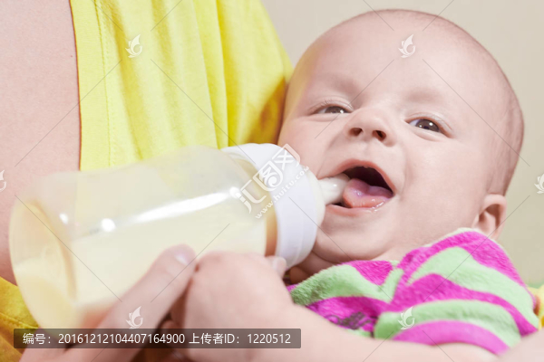 小嬰兒的微笑和瓶子在母親和