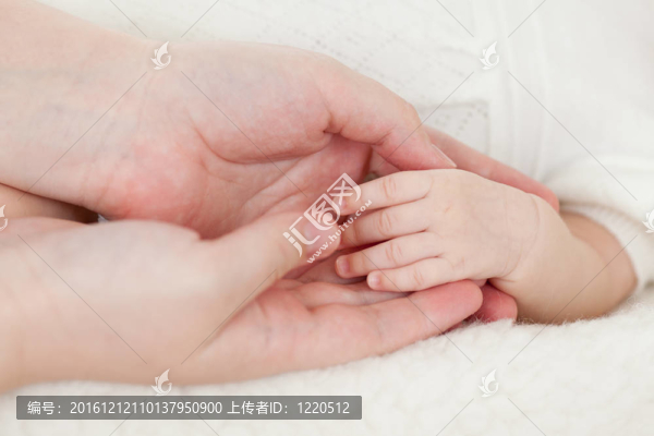 父母的手牽著嬰兒的手