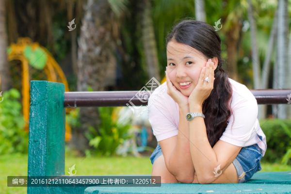 亞洲女子坐在長椅上微笑