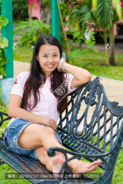 亞洲女子坐在長椅上微笑