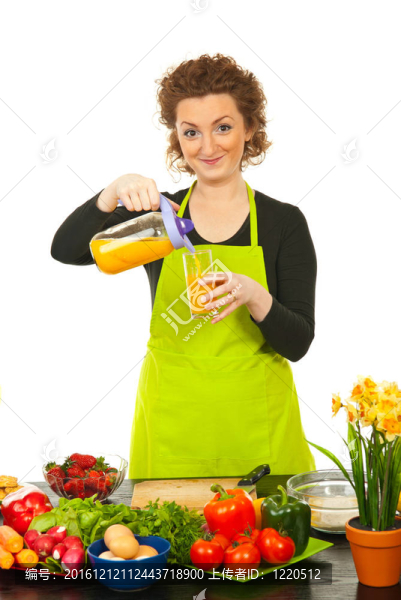 女人在玻璃杯里倒橙汁