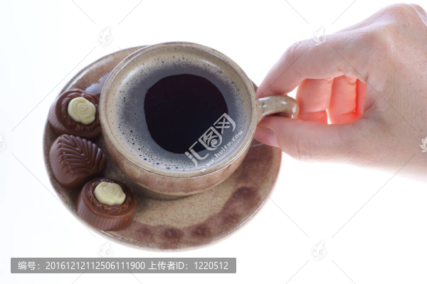 果仁巧克力；杯；黑咖啡和女性手上白色