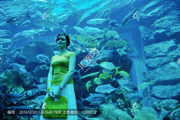 在背景大魚(yú)缸的年輕女子