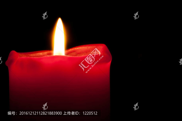 在黑暗中燃燒著橙色火焰的紅燭