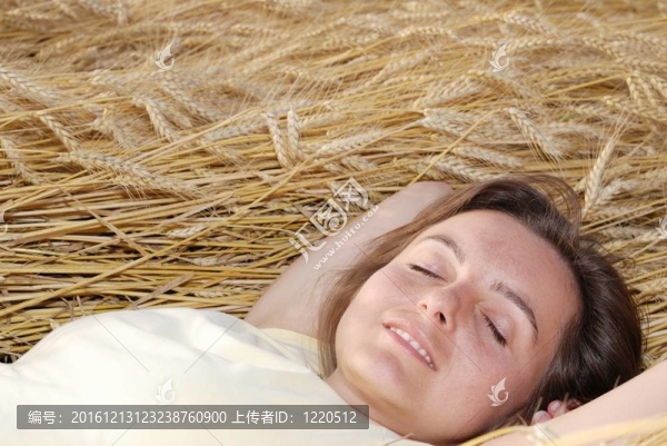 年輕女人躺在金色的谷物里