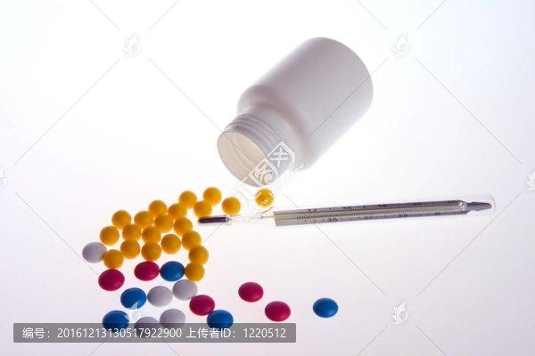 五顏六色的藥片維生素；倒從白色背景上的一瓶和溫度計