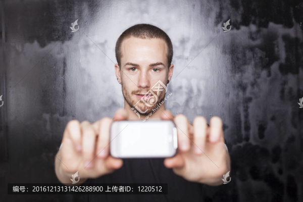 手持智能手機(jī)并顯示顯示屏的男子
