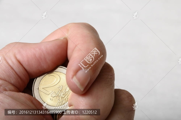 手和手指持有一二歐元硬幣清晰的背景