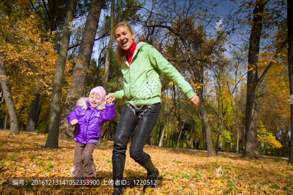 女人將她女兒在秋天的公園