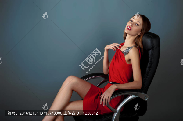 性感女孩穿著紅色的裙子坐在皮椅上