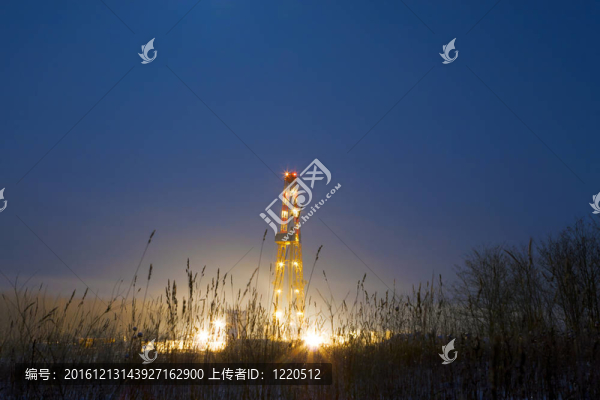 霧中的石油鉆塔；夜間照明。