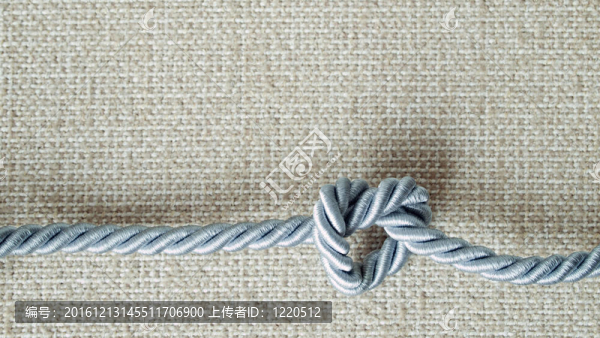 輕灰色繩綁在奶油織物的心形
