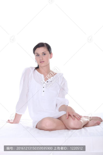 漂亮的年輕女子在白色的床上