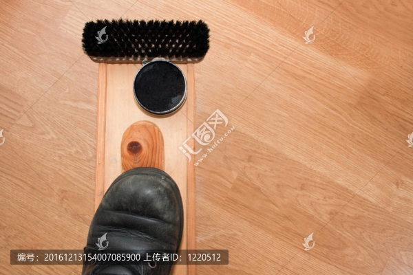 在待拋光的盒子上磨損的鞋子