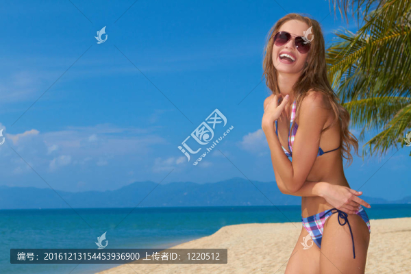 沙灘上戴墨鏡的微笑女人