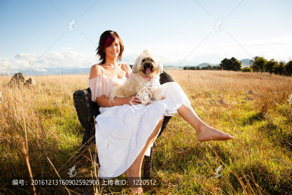 在她的膝蓋上一只貴賓犬在野外女人