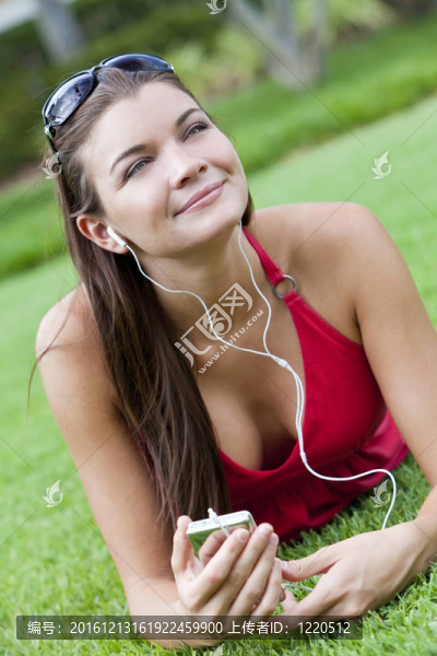 美麗的黑發(fā)女人躺下來聽MP3播放器