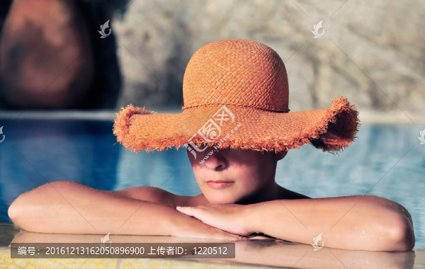 迷人的年輕女子在帽子旁邊的池