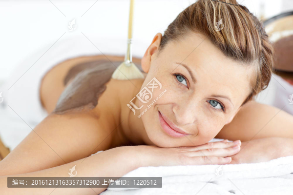 輕松的年輕女子享受著與泥美容