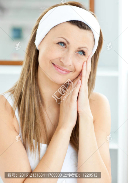 年輕的女人把奶油在她的臉上戴著家里的浴室一頭帶