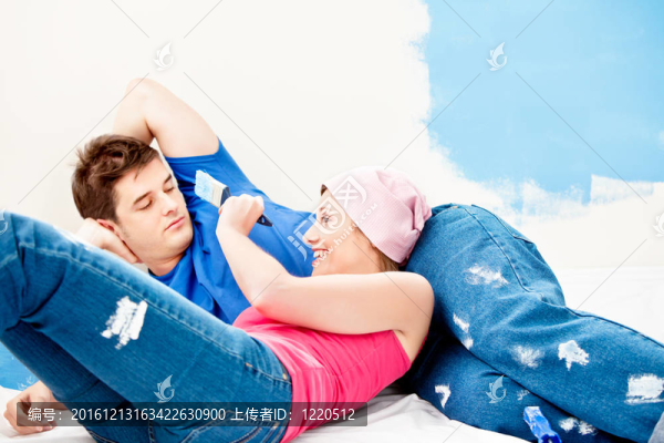 年輕白人夫婦在油漆房間后放松