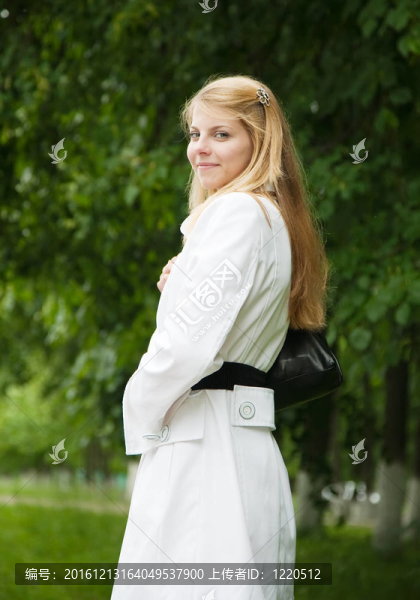 穿著白色斗篷的女孩站在戶外