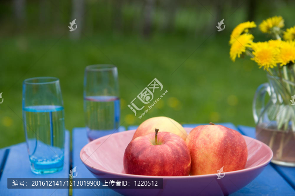 花園桌上的蘋果和玻璃杯