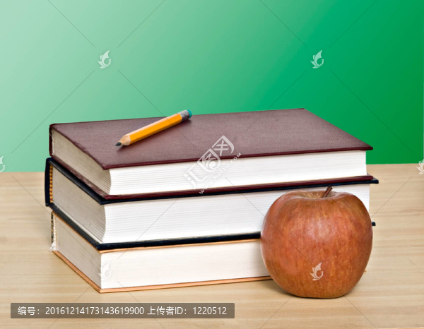 紅蘋果和鉛筆在書的頂端