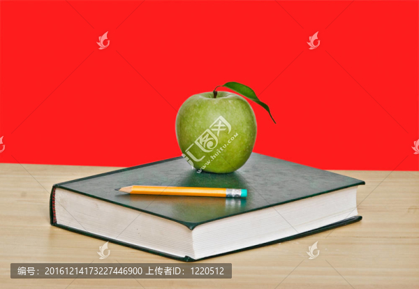 綠色蘋果和鉛筆在書的頂部