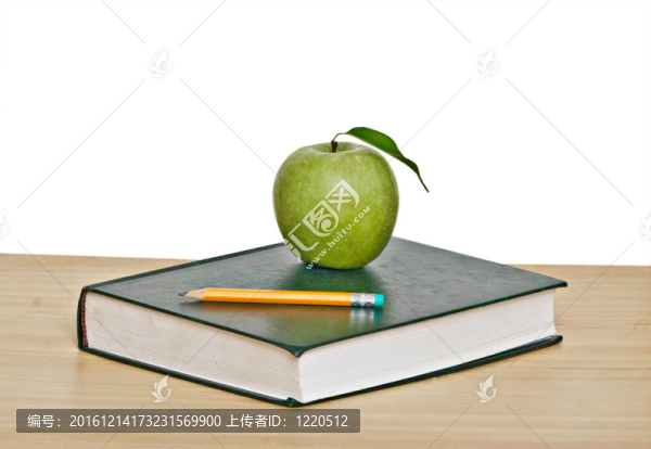 綠色蘋果和鉛筆在書的頂部