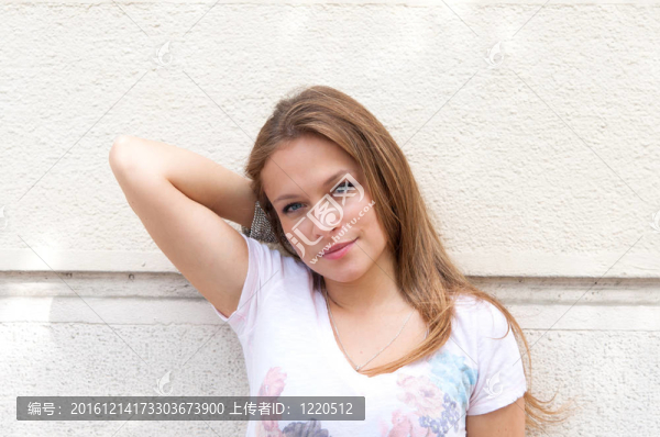 站在白色墻上的年輕女子
