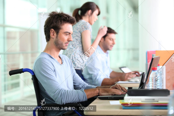 三人在銷售部工作，其中一人坐在輪椅上。
