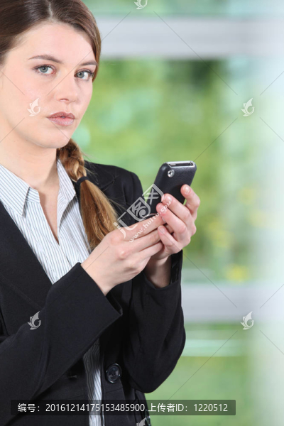 年輕的女商人檢查電話。