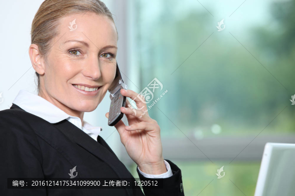 在電話旁邊窗口的女商人。
